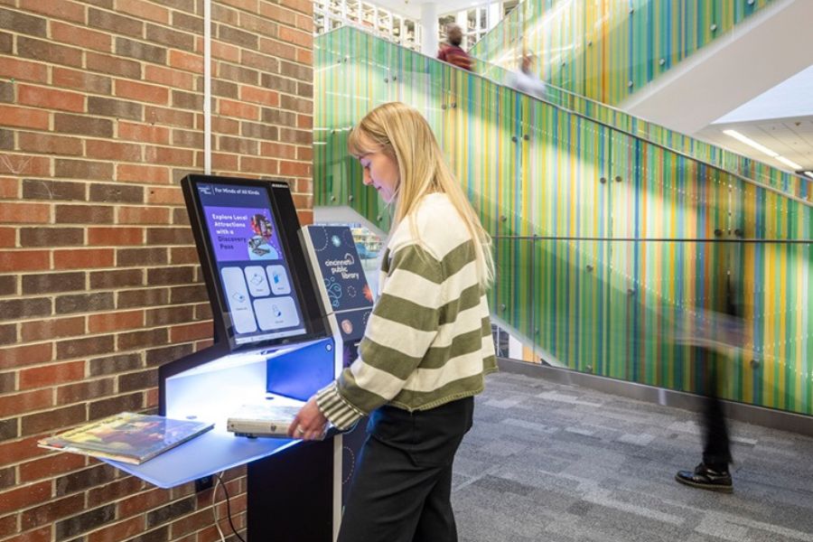 A patron checks out materials using the selfCheck 1000 kiosk at Cincinnati & Hamilton County Public Library’s Main Library.