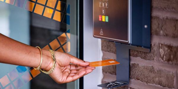 A patron scanning a library card at an access control panel, using open+ at Gwinnett County Public Library, US, where access increased by over 3,600%.