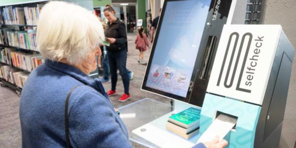 A patron using the selfCheck™ kiosk at Manawatū Community Hub Libraries, NZ, where hundreds have signed up for open+ extended access.