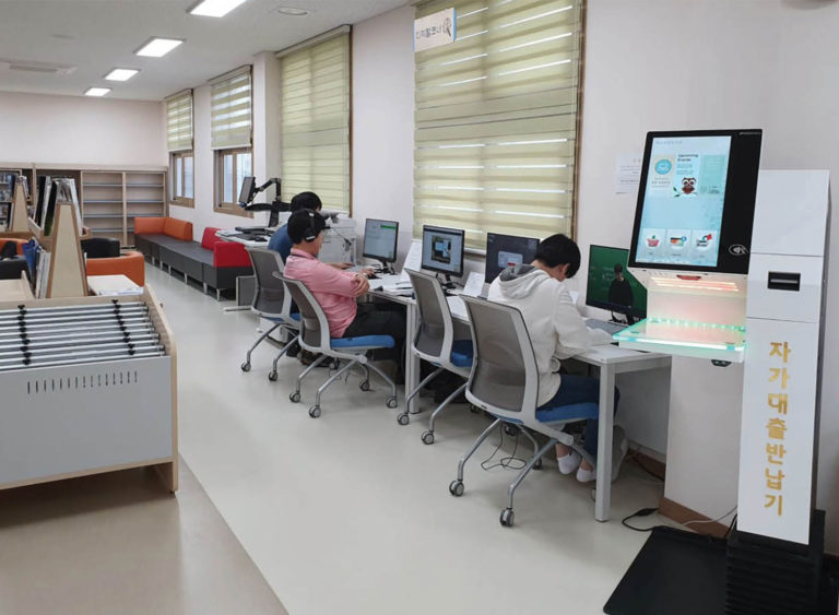 Selfcheck 1000 and people on computers in Haenam library