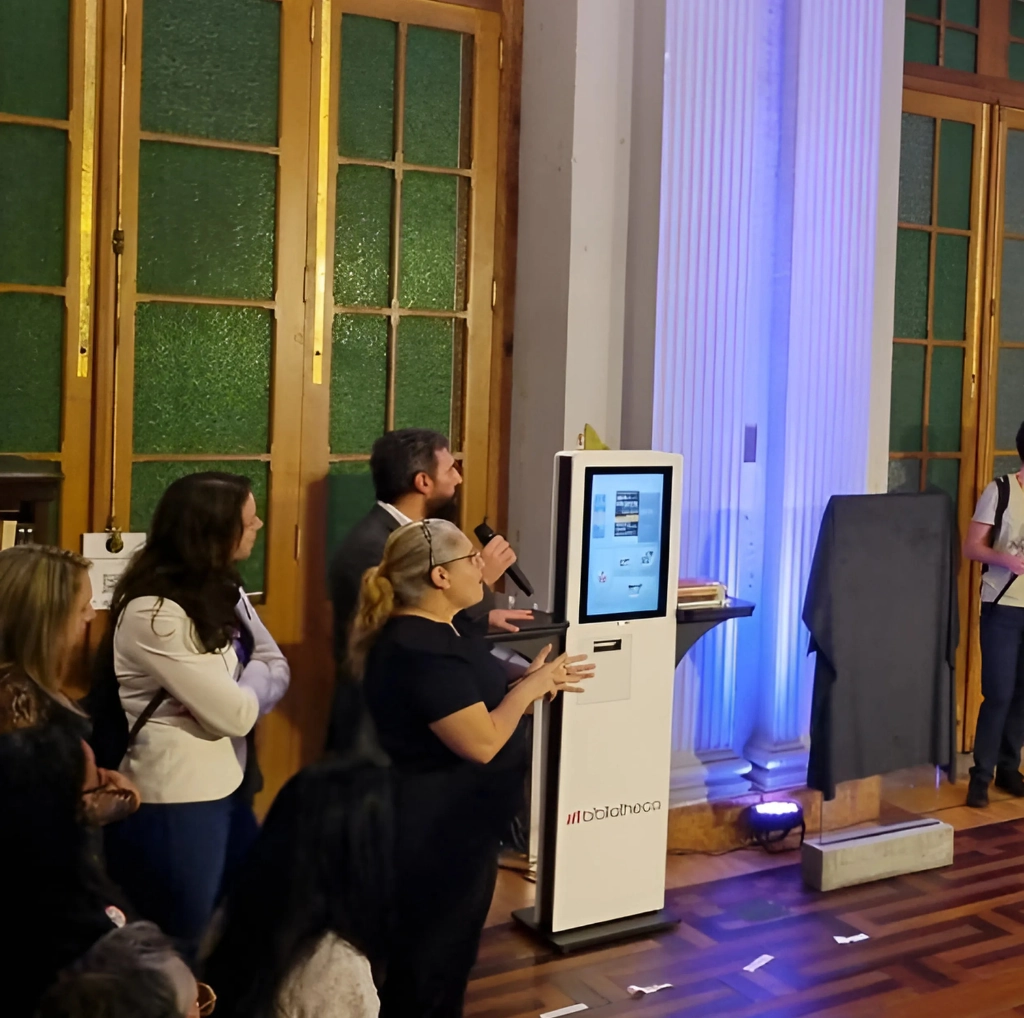 Biblioteca Pública do Estado do Rio Grande do Sul adota quiosque sustentável de autoatendimento 4 Executivo da Bibliotheca, João Ramos, demonstra o funcionamento do quiosque de autoatendimento selfCheck 600eco durante cerimônia na Biblioteca Pública do RS