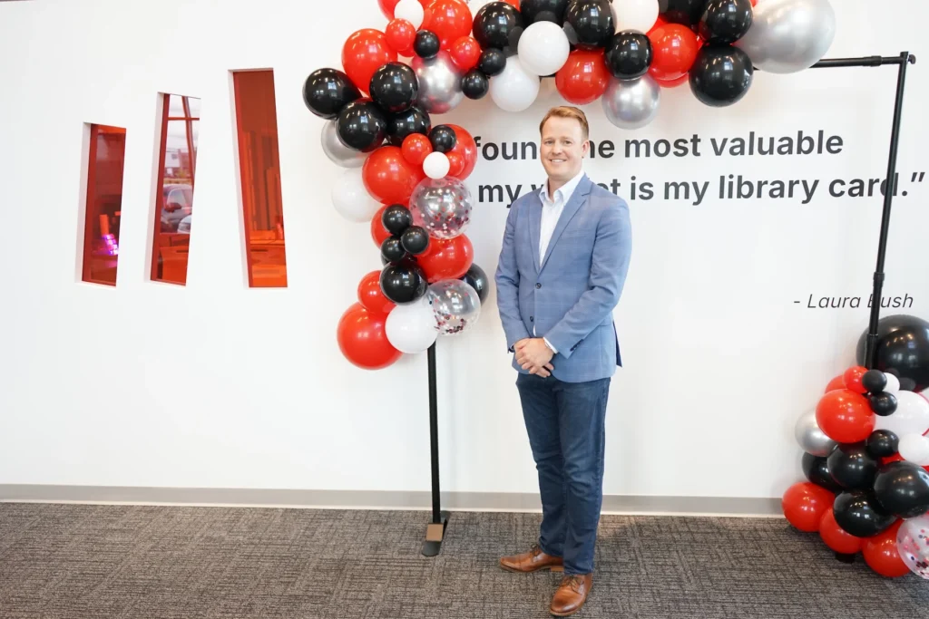 Matthew Bellamy poses by a balloon display during his welcome event as new CEO of Bibliotheca