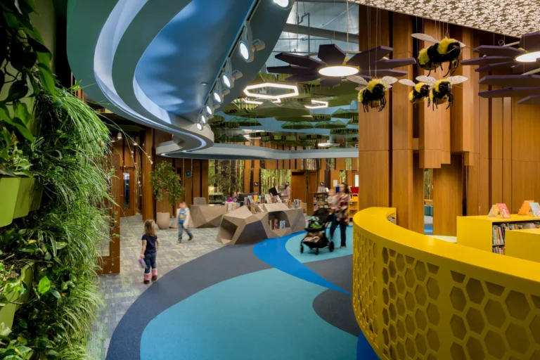 Self-Service Checkout 11 Children's area at Redford Township District Library with colorful design, plants, and bee decorations.